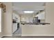 Open kitchen featuring white cabinets, tile flooring, and a breakfast bar at 4065 Kingsley St, Clermont, FL 34711