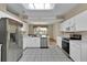 Well-lit kitchen features white cabinets, stainless steel appliances, an open layout, and a tile floor at 4065 Kingsley St, Clermont, FL 34711