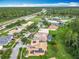 Aerial view of neighborhood homes with solar panels, lush green lawns, and proximity to highways and green spaces at 4109 Vessel Ct, Kissimmee, FL 34746