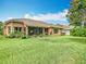 Spacious backyard featuring lush green grass, a screened-in lanai, and mature landscaping at 4109 Vessel Ct, Kissimmee, FL 34746
