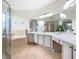 Spacious bathroom with large vanity, mirrors, garden tub, and tiled shower with a glass door at 4109 Vessel Ct, Kissimmee, FL 34746