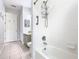 Bathroom featuring tiled floors and shower with white tiles, grab bar, and a toiletry caddy at 4109 Vessel Ct, Kissimmee, FL 34746