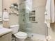 Bathroom with tiled shower featuring a glass door, a toilet, and decorative shelves with accessories at 4109 Vessel Ct, Kissimmee, FL 34746