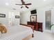 Bright bedroom featuring a ceiling fan, television, wood dresser with a mirror, and light colored carpet at 4109 Vessel Ct, Kissimmee, FL 34746