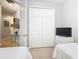Bedroom with a white bed, TV and a closet featuring a door leading to a hallway with pictures at 4109 Vessel Ct, Kissimmee, FL 34746