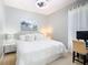 Comfortable bedroom featuring white bedding, a ceiling fan, and a beach-themed print hanging on the wall at 4109 Vessel Ct, Kissimmee, FL 34746