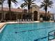 Relax by the sparkling community pool with lane lines and comfortable lounge chairs with palm trees at 4109 Vessel Ct, Kissimmee, FL 34746