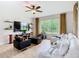 Bright living room with large windows, a white sectional, dark armchairs, and a ceiling fan at 4109 Vessel Ct, Kissimmee, FL 34746