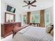 Well-lit main bedroom featuring dark wood furniture, a ceiling fan, and bright windows with natural light at 4109 Vessel Ct, Kissimmee, FL 34746