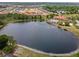Community aerial view of a tranquil lake with lush landscaping and nearby homes, showcasing the neighborhood at 423 Paloma Dr, Davenport, FL 33837