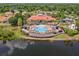 Community aerial view featuring a pool and clubhouse next to a calm lake surrounded by greenery at 423 Paloma Dr, Davenport, FL 33837