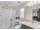 A bathroom features a glass-enclosed shower, a gray vanity with a sink, and a toilet at 423 Paloma Dr, Davenport, FL 33837