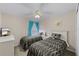 A bedroom has two twin beds with patterned bedding, a ceiling fan, and blue curtains at 423 Paloma Dr, Davenport, FL 33837