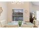 A dining room with cream walls, a wooden table with blue placemats, and a window with views of the backyard at 423 Paloma Dr, Davenport, FL 33837