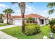 Charming single-story home featuring a red tile roof, lush landscaping, and a two-car garage at 423 Paloma Dr, Davenport, FL 33837