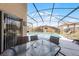 Screened-in pool and patio area with a dining table and lounge chairs at 423 Paloma Dr, Davenport, FL 33837