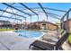 Sparkling in-ground pool with deck chairs and a screened-in enclosure at 423 Paloma Dr, Davenport, FL 33837