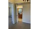 Hallway with view into bathroom with wooden cabinets, white sink and framed mirror at 429 Fountainhead Cir # 223, Kissimmee, FL 34741