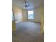 Open living area with neutral carpet, ceiling fan, and natural light from a large window at 429 Fountainhead Cir # 223, Kissimmee, FL 34741