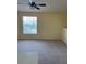 The bright living room features neutral carpeting, a ceiling fan, and a sunlit window at 429 Fountainhead Cir # 223, Kissimmee, FL 34741