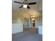 Open-concept living room with a ceiling fan, neutral carpeting, and a view into the bathroom at 429 Fountainhead Cir # 223, Kissimmee, FL 34741