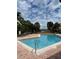 Community pool with a handrail, lounge chairs, and a scenic view, perfect for relaxation and recreation at 429 Fountainhead Cir # 223, Kissimmee, FL 34741