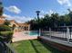 Community pool with a nearby clubhouse, surrounded by a brick deck, lush landscaping, and ample seating at 429 Fountainhead Cir # 223, Kissimmee, FL 34741
