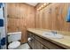 Bathroom featuring wood paneling, single vanity, and a toilet at 4307 Oak Ct, St Cloud, FL 34769