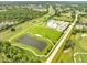 Aerial view of the community park with a pond, pool, playground, and athletic field at 440 Peppermill Cir, Kissimmee, FL 34758