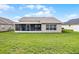 A sprawling backyard, lush green lawn and screened in porch at 440 Peppermill Cir, Kissimmee, FL 34758
