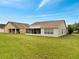 Beautiful green backyard with view of the screened-in porch and neighborhood houses at 440 Peppermill Cir, Kissimmee, FL 34758