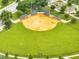 Aerial shot of a well-maintained baseball field with green grass, bases, and lights at 440 Peppermill Cir, Kissimmee, FL 34758