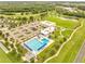 Aerial view of a sparkling community pool, clubhouse, and adjacent parking area at 440 Peppermill Cir, Kissimmee, FL 34758