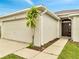 Charming house exterior featuring a garage, front door, and well-manicured landscaping at 440 Peppermill Cir, Kissimmee, FL 34758