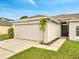 Single story home featuring a two-car garage, well-manicured lawn, and an inviting front entrance at 440 Peppermill Cir, Kissimmee, FL 34758