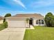 Charming single-story home featuring a two-car garage, well-maintained lawn, and inviting curb appeal at 440 Peppermill Cir, Kissimmee, FL 34758
