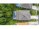 Overhead view of home with roof and screened pool; bordered with green grass at 4697 Golden Beach Ct, Kissimmee, FL 34746