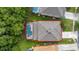 Overhead view of home with roof and screened pool; bordered with green grass at 4697 Golden Beach Ct, Kissimmee, FL 34746