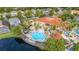 Aerial view featuring the community pool with lounge chairs and tables, and the clubhouse surrounded by lush green landscape at 4697 Golden Beach Ct, Kissimmee, FL 34746