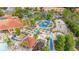 Aerial view showcasing the basketball court, playground, and picnic area surrounded by tropical trees and the community clubhouse at 4697 Golden Beach Ct, Kissimmee, FL 34746