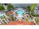 Aerial view highlighting the pool, playground, and hot tub, with seating, lush landscaping, and mature trees at 4697 Golden Beach Ct, Kissimmee, FL 34746
