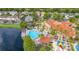 Aerial view of the community pool, spa, and clubhouse overlooking a beautiful lake surrounded by lush landscaping and homes at 4697 Golden Beach Ct, Kissimmee, FL 34746