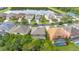 An aerial view of a neighborhood with a tranquil lake and homes with screened-in pools at 4697 Golden Beach Ct, Kissimmee, FL 34746