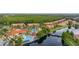 Aerial view of a beautiful community featuring a pool, lake, clubhouse, and colorful townhomes surrounded by lush greenery at 4697 Golden Beach Ct, Kissimmee, FL 34746