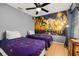 Bedroom with two twin beds, mural, wood-look floors, ceiling fan, and window at 4697 Golden Beach Ct, Kissimmee, FL 34746