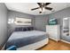 Cozy bedroom featuring gray walls, wood floors, and ceiling fan, complete with a television and dresser at 4697 Golden Beach Ct, Kissimmee, FL 34746
