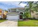 Charming two-story home featuring a two-car garage, arched entry, and lush landscaping at 4697 Golden Beach Ct, Kissimmee, FL 34746