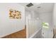 Bright hallway with wood floors, decorative wall art and natural light from the stairwell window at 4697 Golden Beach Ct, Kissimmee, FL 34746