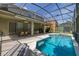 A screened-in pool area featuring a luxurious in-ground pool and a spacious covered patio with outdoor seating at 4697 Golden Beach Ct, Kissimmee, FL 34746
