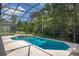 A screened-in swimming pool with a connected spa surrounded by lush greenery and offering a private oasis at 4697 Golden Beach Ct, Kissimmee, FL 34746